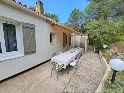 a table and chairs sitting outside of a house at Rooms with sculptor in Pinèdes in Aurons