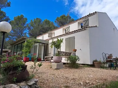 a white house with a patio in front of it at Rooms with sculptor in Pinèdes in Aurons