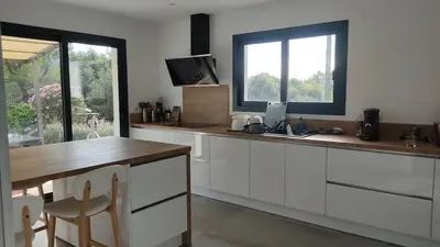 a kitchen with white cabinets and a table and a window at Villa la grande Bastide in Oppède