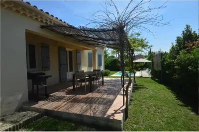 a porch of a house with a table and chairs at Les Abricotiers in Caromb