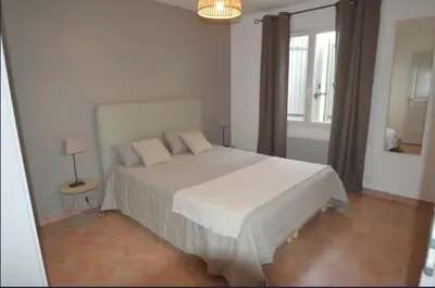 a bedroom with a large white bed and a window at Les Abricotiers in Caromb
