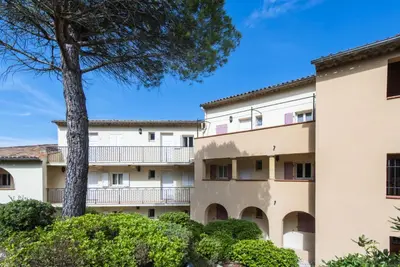 an apartment building with a tree and bushes at Village Pont Royal en Provence - maeva Home - Appartement climatisé 4 pièces 6 personnes - Sélection - super Home MAE-7473 in Mallemort