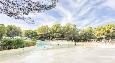 a rendering of a beach with people in the water at Village Pont Royal en Provence - maeva Home - Appartement climatisé 4 pièces 6 personnes - Sélection - super Home MAE-7473 in Mallemort