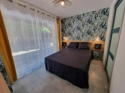 a bedroom with a bed and a large window at Gîtes de la Coupière Le Mûrier in Aubenas-les-Alpes