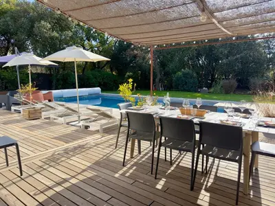 a patio with a table and chairs and a pool at -La Garrigue Paradis-Maison de Vacances entièrement climatisée 5 chambres avec piscine-10 personnes in Rognes