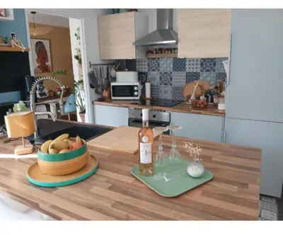 a kitchen with a table with a bowl of fruit on it at Maison climatisée avec jaccuzi in Eyguières