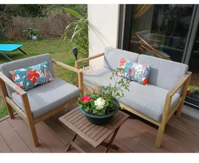 two chairs and a pot of flowers on a patio at Maison climatisée avec jaccuzi in Eyguières