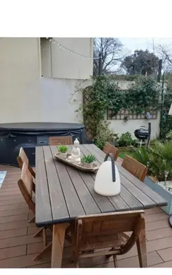 a wooden table and chairs on a patio at Maison climatisée avec jaccuzi in Eyguières