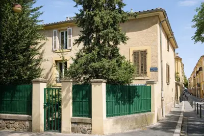 a house with a green gate and a tree at Studio Aix Centre idéal séjour pro & tourisme in Aix-en-Provence