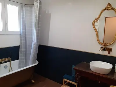 a bathroom with a sink and a tub and a mirror at Gîte de la Transhumance - 80m2 in Rognes