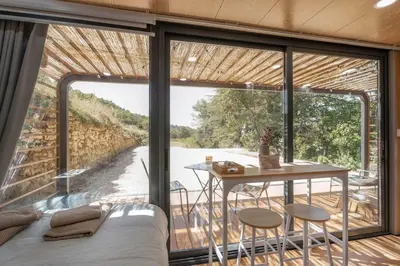 a room with a bed and a table and a large window at Sous les étoiles du Luberon, Tiny House, Ménerbes in Ménerbes