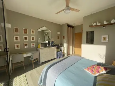 a bedroom with a bed and a desk with a computer at 1 Brin à part in Maubec