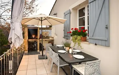 a table with chairs and an umbrella on a patio at Maison Avec Piscine 1 in Mormoiron