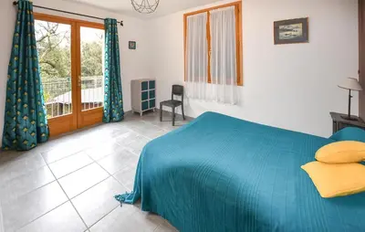 a bedroom with a blue bed and a balcony at Maison Avec Piscine 1 in Mormoiron