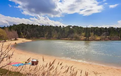 a beach with a kite on the shore of a lake at Maison Avec Piscine 1 in Mormoiron
