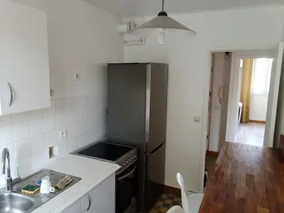 a kitchen with a stainless steel refrigerator and a table at Colocation 3 chambres - Prix pour 1 chambre - Proche centre-ville historique à pied in Aix-en-Provence