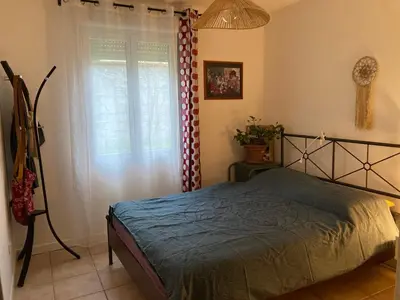 a bedroom with a bed and a window at Charmant appartement velleron in Velleron