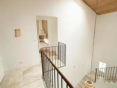 a staircase in a white room with a mirror at Le Mas des Poètes in Saint-Andiol