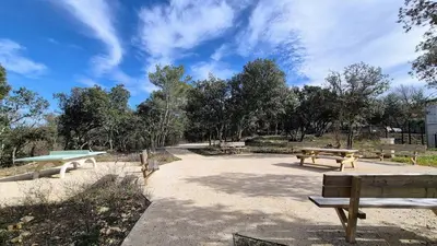 two picnic tables and benches in a park at Villa Quercus Design Piscine et Loisirs in Ménerbes