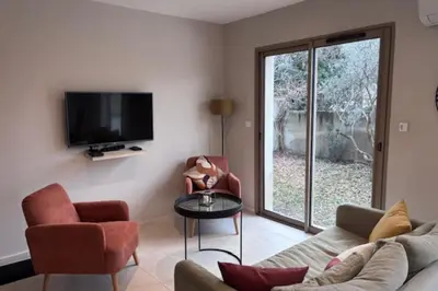 a living room with a couch and chairs and a tv at Lou Cabanon in LʼIsle-sur-la-Sorgue