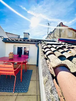 a patio with a red table and chairs on a roof at Rare duplex with rooftop terrace in Aix-en-Provence