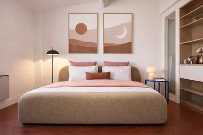 a bedroom with a bed with two pictures on the wall at Rare duplex with rooftop terrace in Aix-en-Provence