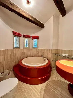 a bathroom with a large tub and a toilet at Air-conditioned Provençal country house with pool in Jouques