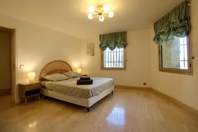 a bedroom with a bed and two windows at Air-conditioned Provençal country house with pool in Jouques