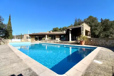 a swimming pool in front of a house at Air-conditioned Provençal country house with pool in Jouques