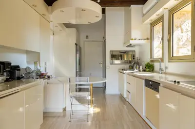 a kitchen with white cabinets and a table and chairs at Air-conditioned Provençal country house with pool in Jouques