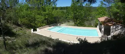a swimming pool in the middle of a hill at Le pré de la Chaumette in Pierrevert