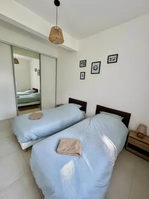 two beds in a bedroom with a mirror at 4-bedroom house with a pool in LʼIsle-sur-la-Sorgue