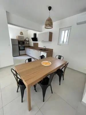 a kitchen and dining room with a wooden table and chairs at 4-bedroom house with a pool in LʼIsle-sur-la-Sorgue