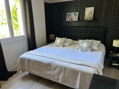 a bedroom with a large bed with blue sheets and pillows at Les hirondelles Piscine privée climatisation billard calme 4 lits in LʼIsle-sur-la-Sorgue