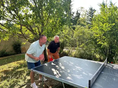 two men standing next to a ping pong table at Les hirondelles Piscine privée climatisation billard calme 4 lits in LʼIsle-sur-la-Sorgue