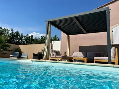 a swimming pool with a pergola next to a house at Les hirondelles Piscine privée climatisation billard calme 4 lits in LʼIsle-sur-la-Sorgue