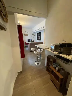 a living room with a table and chairs in a room at Location grand studio centre ville Isle sur la sorgue in LʼIsle-sur-la-Sorgue