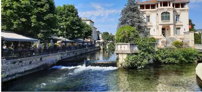 a bridge over a river in a city at Location studio centre ville Isle sur la sorgue in LʼIsle-sur-la-Sorgue