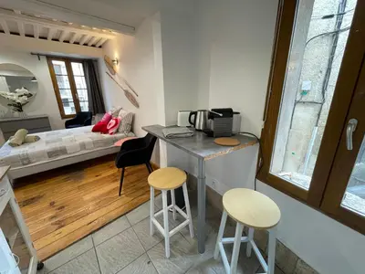a kitchen with a counter and two stools in a room at Location studio centre ville Isle sur la sorgue in LʼIsle-sur-la-Sorgue
