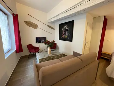a living room with a couch and a table at Location studio centre ville Isle sur la sorgue in LʼIsle-sur-la-Sorgue