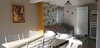 a living room with a couch and a table at Dépendance de charme avec piscine en luberon in Peypin-dʼAigues