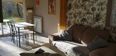 a living room with a couch and a table at Dépendance de charme avec piscine en luberon in Peypin-dʼAigues