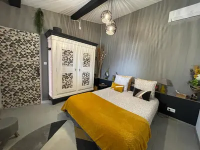 a bedroom with a bed with a yellow blanket at Le Mas de la Butte Blanche in Orgon