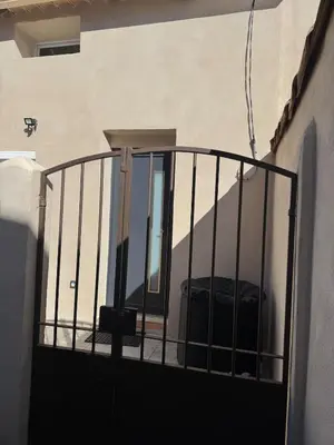 a balcony with a gate in front of a building at Ideal Cyclistes Km0 Ventoux RDC cour parking in Bédoin