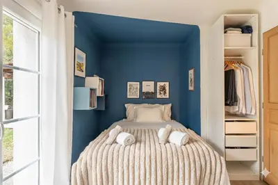 a bedroom with blue walls and a bed with pillows at Aurenza - Piscine - Jardin paysager - Vue campagne in Éguilles