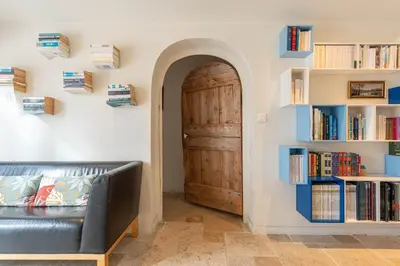 a room with a door and a bench and books at Aurenza - Piscine - Jardin paysager - Vue campagne in Éguilles