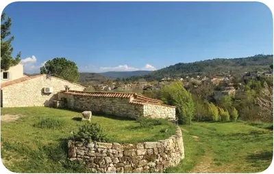 a stone building in a field with a stone wall at Maison provençale in Céreste