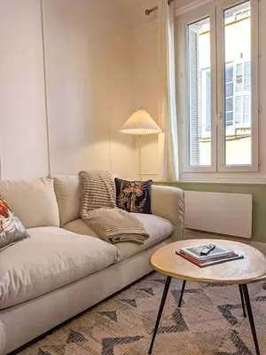 a living room with a couch and a table at Plein centre d'Aix, bel appartement T2 rénové in Aix-en-Provence