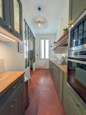 a large kitchen with wooden counter tops and a large window at Plein centre d'Aix, bel appartement T2 rénové in Aix-en-Provence