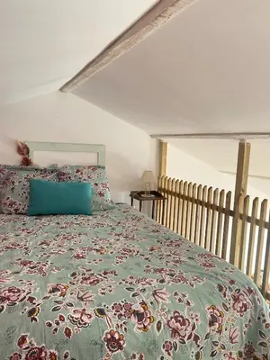 a bedroom with a bed with a green comforter at Ideal festival d'Avignon in Monteux